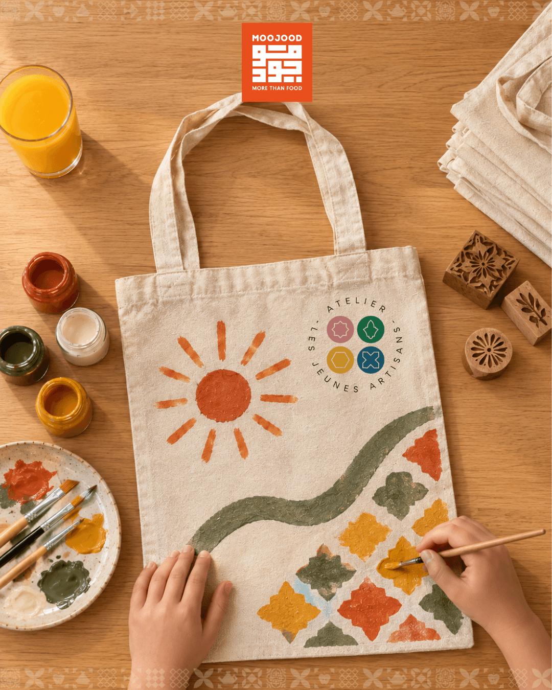 Fenn & Fun Kids visual: a child paints a tote bag with an orange sun and zellige patterns, Moojood and Atelier Les Jeunes Artisans logos.
