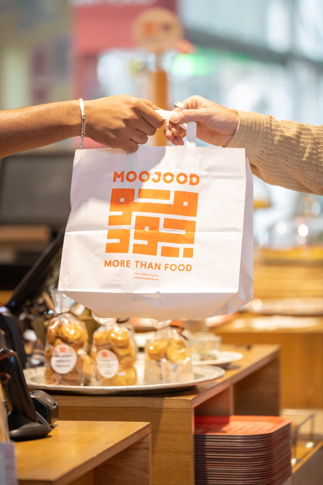 Kraft Moojood bag at the counter, daily pastries in the background.